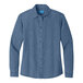 A Port & Company women's faded blue short sleeve denim button-down shirt on a counter.
