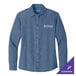 A Port & Company women's long sleeve faded blue denim shirt on a counter.