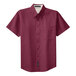 A Port Authority unisex short sleeve dress shirt in burgundy and light stone with a close-up of the fabric.