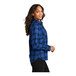A woman wearing a blue plaid Port Authority flannel shirt.