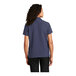 A woman wearing a Port Authority navy blue short sleeve staff shirt.