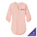 A pink Port Authority tunic with white text on the sleeve.