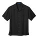 A black Port Authority short sleeve camp shirt with a buttoned collar and pocket.
