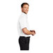 A man wearing a white Port Authority dress shirt with short sleeves.