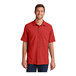 A man wearing a red Port Authority short sleeve shirt.