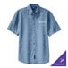 A Port & Company faded blue denim button-up shirt with an embroidered logo.