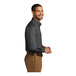 A man standing and smiling wearing a Port Authority graphite long sleeve poplin dress shirt.
