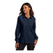 A woman wearing a navy short sleeve Port Authority shirt.