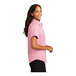 A woman wearing a light pink Port Authority short sleeve dress shirt.