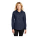 A woman wearing a navy and light stone Port Authority long sleeve dress shirt.