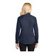 A woman wearing a Port Authority navy and light stone long sleeve dress shirt.