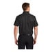 A man wearing a black Port Authority short sleeve dress shirt.
