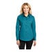 A woman wearing a Port Authority teal green long sleeve dress shirt.