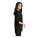 A woman wearing a black Port Authority short sleeve blouse.