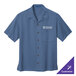 A blue Port Authority short sleeve camp shirt with a logo on it.