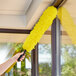 A hand holding a yellow Ettore Elite MicroSwipe duster.