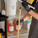 A person holding a tool with a threaded aluminum pole handle.