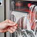 A hand using an Ettore 6" acrylic squeegee to clean a window.