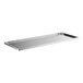 A silver stainless steel undershelf for a white rectangular work table.