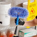 A person holding a blue Ettore ceiling fan brush.