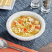 A bowl of Kettle Cuisine chicken noodle soup with noodles and chicken.