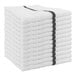 A stack of white Monarch Brands bar towels with black stripes.