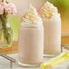 Two glasses of Dr. Smoothie Salted Caramel Latte with whipped cream and straws.