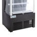 An Avantco black refrigerated air curtain merchandiser with a glass door.