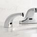 A Waterloo chrome automatic soap dispenser sitting on a white counter.