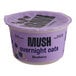 A case of Oats Overnight Blueberry Mush on a table with a purple lid.