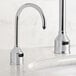 A Waterloo tall chrome automatic soap dispenser with foam spout on a white counter.