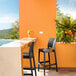 A Siesta Maya dark gray bar stool on an outdoor patio overlooking the ocean.