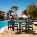 A Siesta Ares black standard height table and chairs on an outdoor patio.