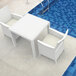 A Siesta Orlando white wicker-look table and chairs on an outdoor patio by a pool.