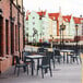 A Siesta Orlando dark gray wicker-look table and chairs on a brick patio.