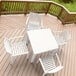 A white Siesta Ares table and chairs on a deck.