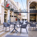 A Siesta Sky dark gray square table and chairs on a patio.