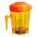 An orange Vitamix blender jar with a lid on top.