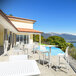 A white Siesta Sky bar height folding table on an outdoor patio next to a pool.