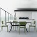 A dining table with Siesta Lisa olive green chairs in a white room.