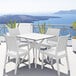A Siesta Florida white wickerlook resin outdoor dining chair next to a table on a patio.