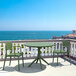 An olive green Siesta Sky table and chairs on a patio.