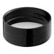 A black round plastic spice container with a white lid with a foam liner.