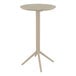 A taupe round bar height table with a metal base.