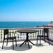 A Siesta Sky round black table with a black metal base on a patio.