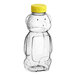 A clear plastic Bear honey bottle with a yellow flip top lid.