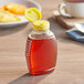 An 8 oz. Queenline PET honey bottle with a yellow plastic flip top lid.