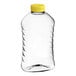 A clear plastic Ribbed Hourglass PET Honey bottle with a yellow flip top lid.