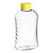 A clear plastic Ribbed Hourglass PET honey bottle with a yellow cap.