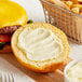 A cheeseburger with a bun and Ken's Real Mayonnaise on a cutting board.